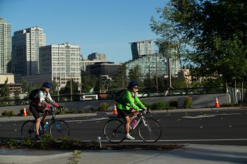 image of bicyclists riding with downtown skyline in backgrou