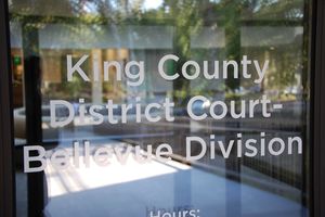 image of glass door with text reading "King County District Court - Bellevue Division"